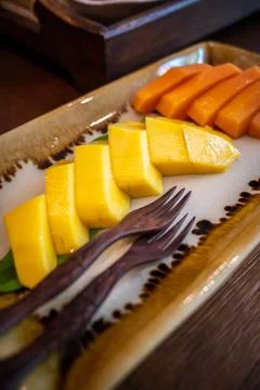 Close up on yellow mango on fruit dish. Stock Photos