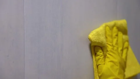 Close-up of yellow microfiber cloth wiping smooth white surface for cleaning and Stock Footage 346202756