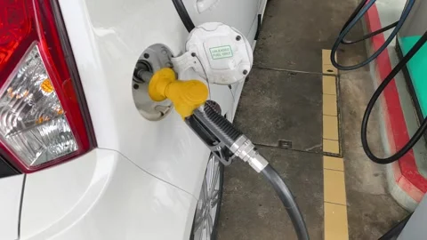 Close Up of Yellow Petrol Nozzle Refueling a Car at Gas Station Stock Footage 331759819