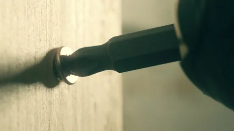 Close-up yellow self tapping screw unscrewing from wall by man. Macro view Stock Footage 309328261