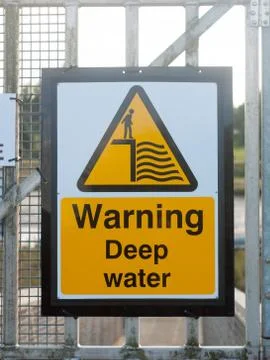 Close up yellow sign at dock warning deep water Stock Photos