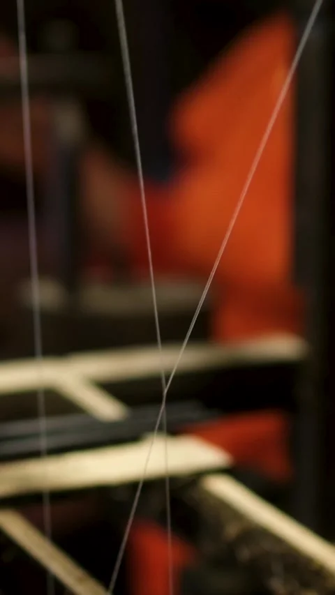 Close up of yellow silk cocoons being unraveled into fine silk threads from hot Stock Footage 318228351