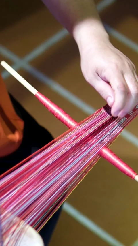 Close up of yellow silk cocoons being unraveled into fine silk threads from hot Stock Footage 318228365