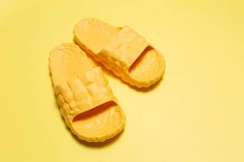 Close-up of yellow slippers on yellow background. Stock Photos
