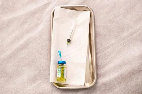 Close-up of a yellow solution in transparent glass bottle in a metallic plate Stock Photos