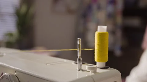 Close-up of Yellow Thread Feeding from Spool on Sewing Machine Closeup 库存影片 341946930