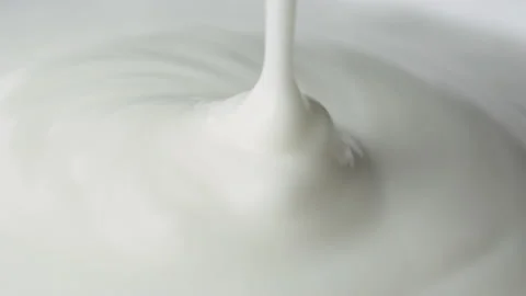Close-up of yogurt poured into a rotating cup Vidéo 186940187