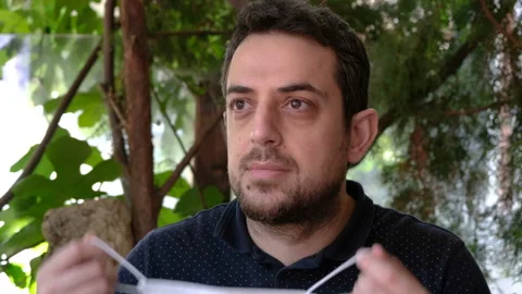 Close-up young adult putting on surgical mask. Concept of health and safety life Stock Footage 134055090