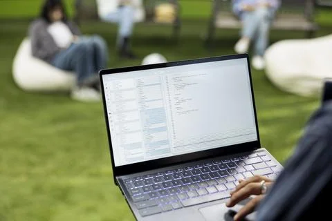 Close up of young adult working on binary code programming with laptop Foto stock