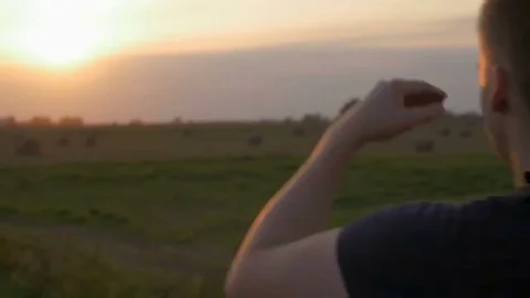 Close-up of young adventurous man standing in the field and looking to sun. Stock Footage 82234388