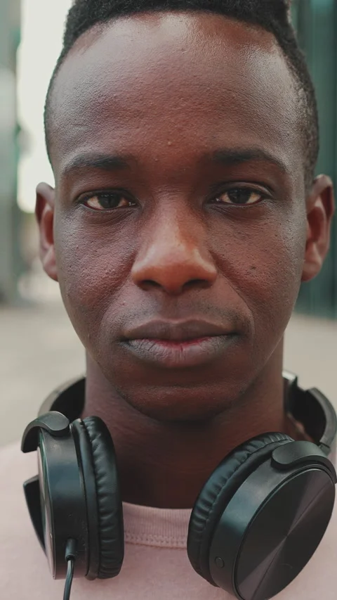 Close-up of young african student standing outside of university in headphones Stock Footage 226936333