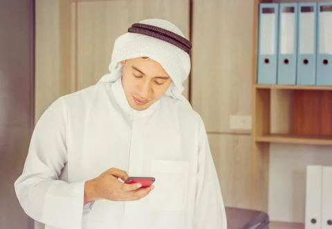 Close up of young Arab Middle Eastern Businessman using mobile smartphone Фото