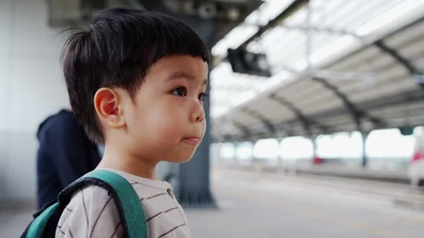 Close-up of a young Asian boy and mother waiting for a commuter train Stock Footage 292854833