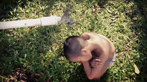 Close up young asian boy taking water from old faucet in the garden.  Stock Footage 73561029