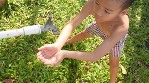 Close up young asian boy taking water from old faucet in the garden.  스톡 동영상 73561041