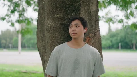 Close-up of young Asian man crying looking ahead with hope and listening  Stock Footage 283187187