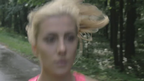 Close-up of young athletic female jogging on the forest road. 動画素材 132613754