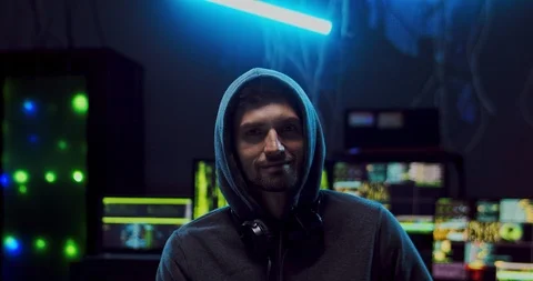 Close up of the young attractive Caucasian guy hacker in a hood looking straight Stock Footage 124350845