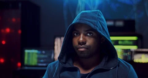 Close up of the young attractive Caucasian guy hacker in a hood looking straight Stock Footage 124350995