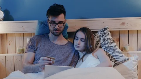 Close up of the young attractive couple lying on the bed in the evening and Stock Footage 106846531