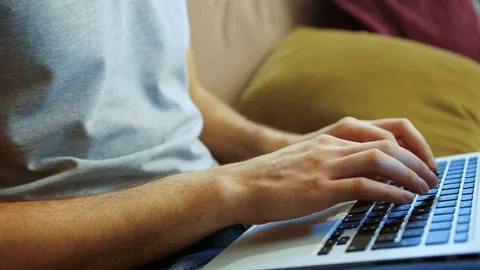 Close up of young attractive man in the glasses working and taping on his laptop Stock Footage 83144146