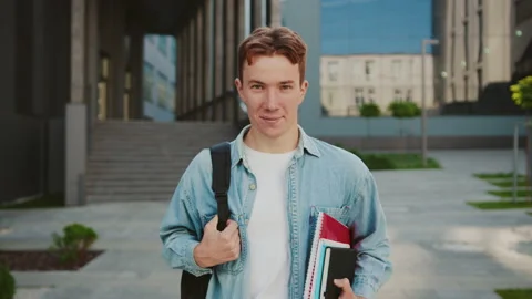 Close up young attractive student man standing look at camera smile at the Stock Footage 142048399