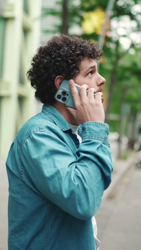 Close-up, young bearded man in denim shirt stands at bus stop waiting for bus Stock Footage 227005581