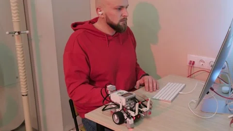 Close up of an young bearded man that is learning robotics lessons using Stock Footage 155810518