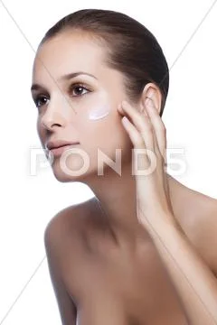 Close-up young beautiful face of girl applying moisturize cream - isolated Stock Photos