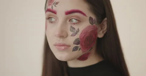 Close-up of a young beautiful girl whose face is beautifully painted with Видео 164470272