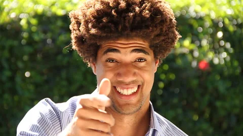 Close Up of young biracial man smiling, makes call-me hand gesture to camera Stock Footage 38763300
