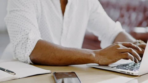Close up of Young Black man hands typing on laptop in modern office. Stock Footage 105360462