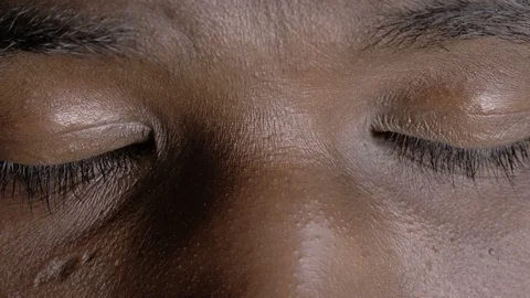 Close up on young black man opening his closed eyes, looking at camera Stock Footage 113420360