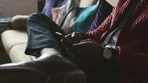 Close Up of Young Black Man Sitting on Sofa and Typing on Smartphone Video stock 59864153
