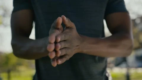 Close-up of young black man in t-shirt rubbing hands together during warm up in Stock Footage 232100744