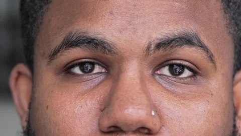 Close-Up Of Young Black Man’s Eyes With Nose Piercing Looking At Camera With Cal Stock Footage 320959788