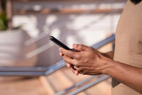 Close up of young black using smartphone app outdoors. Stock Photos