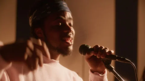 Close Up of Young Black Vocalist Singing into Mic during Band Rehearsal 库存影片 334387028