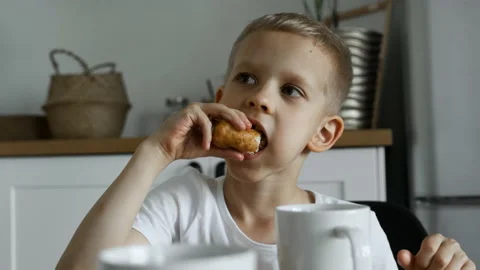 Close-Up Of A Young Boy, A Child Has Lunch, Eats A Pie, Communicates Stock Footage 156845809