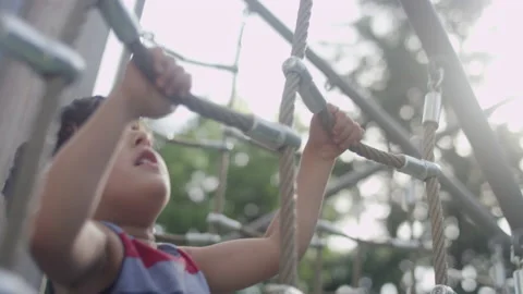 Close-up of a young boy climbing a rope ladder on a playground at the park Stock-Footage 143626050