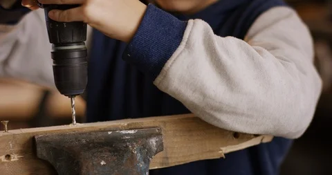 Close up of young boy drilling a hole into wood Stock Footage 85811284