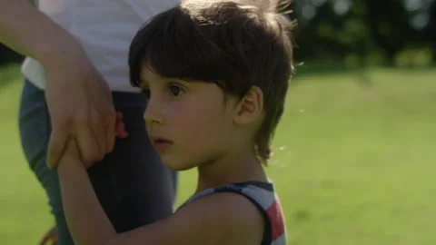 Close-up of a young boy looking around with wonder as he holds his mother's hand Video stock 143630124