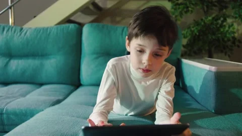 Close Up Young Boy Lying In Bed And Using Digital Tablet. Young Schoolboy Stock Footage 156275982