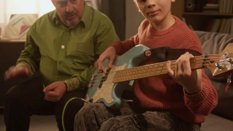 Close Up of Young Boy Playing Electric Guitar with Teacher Cheering Stock Footage 333424830