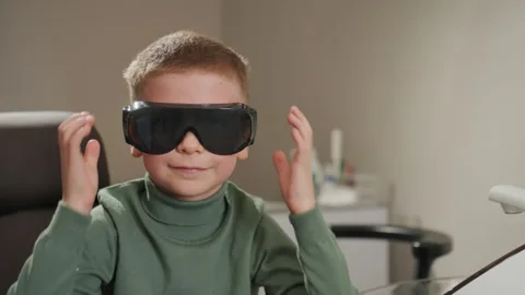 Close up young boy putting protective glasses dental office indoor setting Video stock 345834718