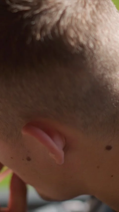 Close up of young boy receiving earplug insertion with visible skin texture Stock Footage 345050340