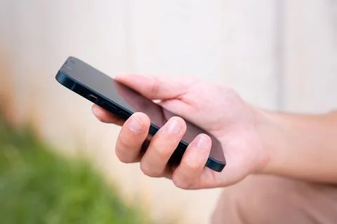 Close up of young boy using smartphone app outdoors. Foto stock