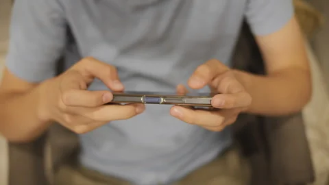Close-up of a young boy's hands using a mobile phone 库存影片 247167162