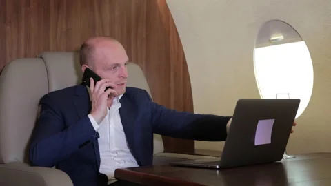 Close Up of a Young Businessman Working at a Computer Talking on the Phone Stock Footage 135150054