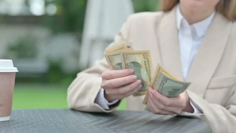 Close up of Young Businesswoman Counting Dollars in Outdoor Cafe Stock Footage 156971663